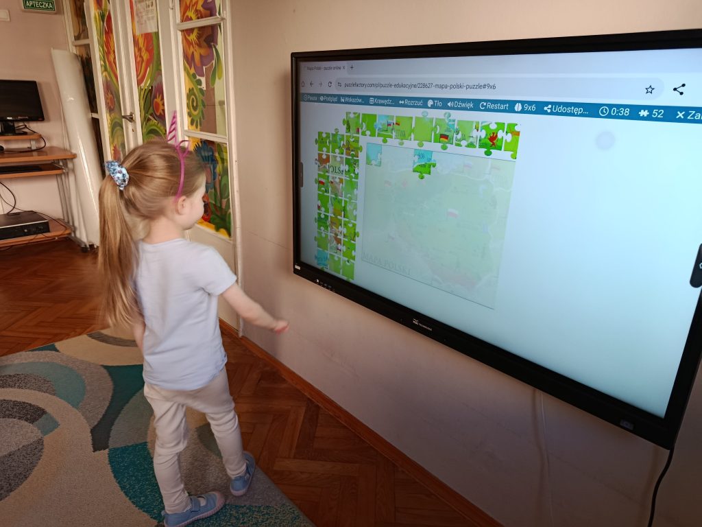 Zdjęcia przedstawiają dzieci podczas zajęć edukacyjnych: z wykorzystaniem instrumentów, krojenie sałatki owocowej, korzystanie z tablicy multimedialnej